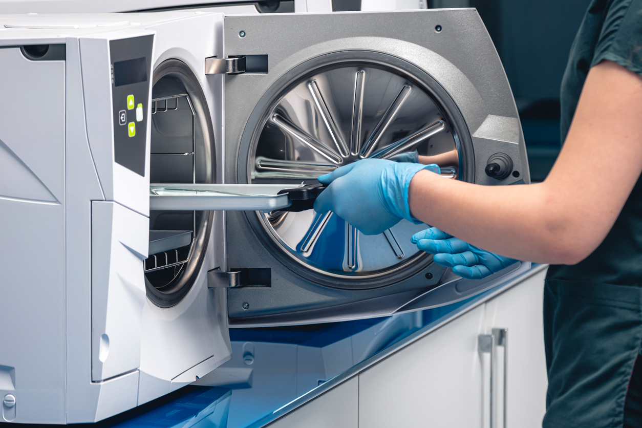 Sterilizing medical instruments in autoclave. Selective focus. Dentist assistant's get out sterilizing medical instruments from autoclave. Sterile dental tools