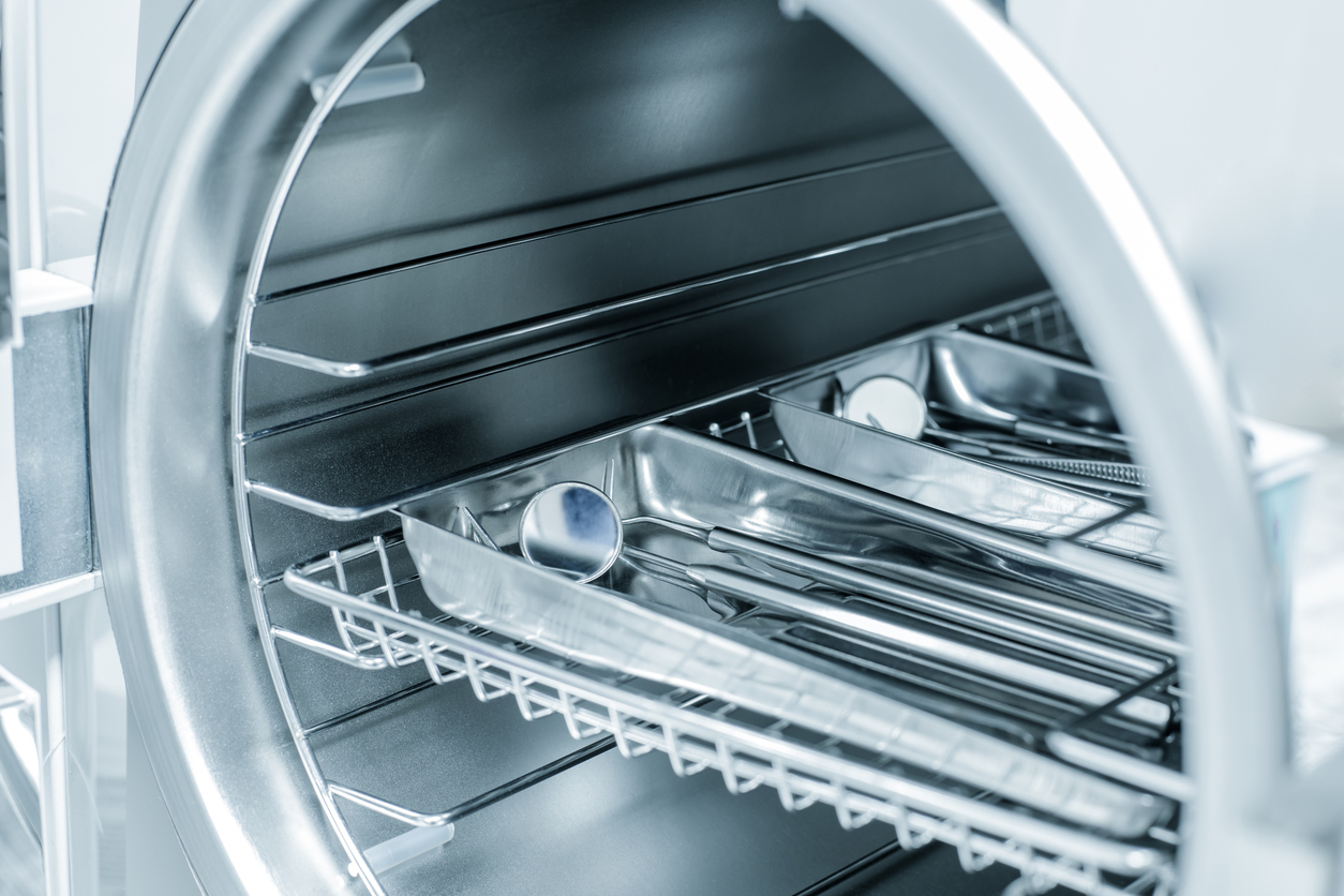 Sterilizing medical instruments in autoclave. Dental office. Selective focus.